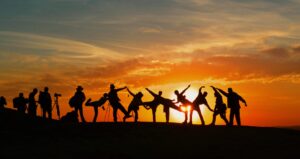group of people posing in different position at sunset