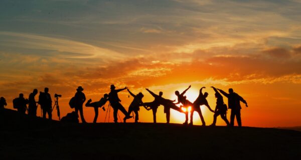 group of people posing in different position at sunset